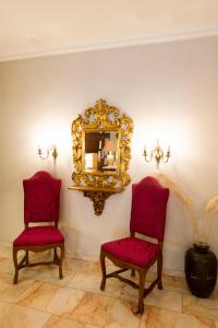 two red chairs and a mirror on a wall at Hotel Alte Post in Wangen im Allgäu