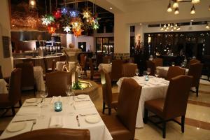a restaurant with tables and chairs with white tablecloths at Hyatt Vacation Club at Sirena del Mar in Cabo San Lucas
