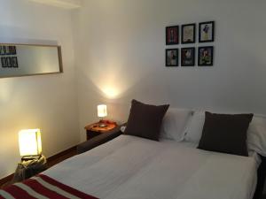 プラジェラートにあるLo Scudo d’Italiaのベッドルーム1室(ベッド1台、ランプ2つ、壁に絵画付)