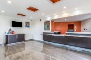 a lobby with a waiting area and a flat screen tv at Motel 6-Oceanside, CA, Marina in Oceanside