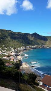 a view of a beach with houses and the ocean at Casa da Fajãzinha in Vila do Porto