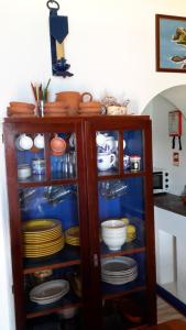 a cabinet full of plates and bowls and dishes at Casa da Fajãzinha in Vila do Porto +7 photos