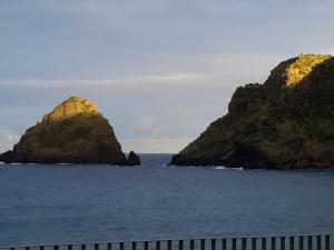 two rocky islands in the water with a fence at Casa da Fajãzinha in Vila do Porto