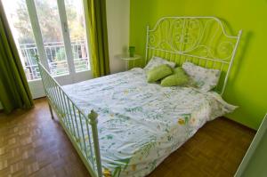 博爾迪蓋拉的住宿－Appartamento Corso Italia "Natura"，一间卧室配有一张白色的床和绿色的墙壁