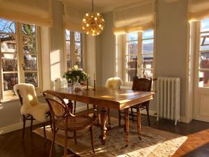 comedor con mesa, sillas y ventanas en Annas Orangerie, en Buchholz