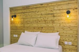 アギオス・プロコピオスにあるAstra Apartmentsのベッドルーム1室(木製ヘッドボード、白い枕付きのベッド1台付)
