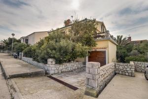 una casa con una pared de piedra y un edificio en Vlasta, en Mali Lošinj