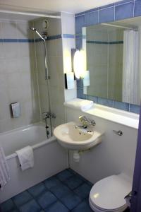 a bathroom with a sink and a toilet and a tub at The Raceby Hotel, Doncaster South Yorkshire, Part of the AG Collection in Doncaster