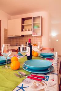 einen Tisch mit Tellern und Weingläsern darauf in der Unterkunft Appartamento Montenero in Pozzallo
