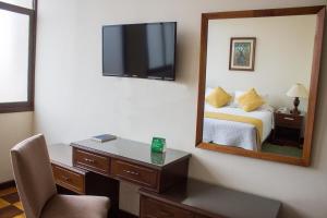 a hotel room with a bed and a mirror at Hotel Victoria Plaza in Tarija +34 photos