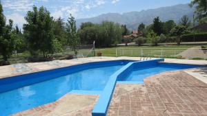 una piscina en un patio trasero con montañas al fondo en Ayres del Bosque en Merlo