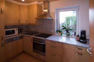 a kitchen with wooden cabinets and a sink and a window at Ferienwohnung Helbig in Allendorf an der Lumda +4 photos