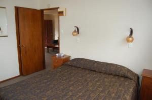 a bedroom with a bed and a wooden door at Carisbrook Motel in Dunedin