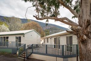 a mobile home with a fence and a tree at The Peaks Halls Gap in Halls Gap