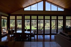 a living room with a table and a large window at Blair Athol Estate Wollombi in Wollombi