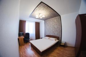 1 dormitorio con cama y espejo grande en Apartment Tatiana, en Yekaterinburg