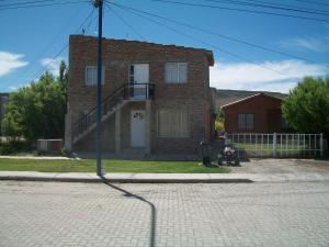 una casa de ladrillo con una puerta blanca en una calle en Hospedaje "San Andres", en Gobernador Gregores