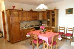 una cocina con armarios de madera y una mesa con flores. en Appartamenti Serena - Nonna Elvira, en Gargnano