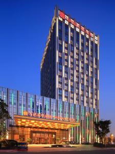 a large building with lights on the front of it at Wanda Realm Neijiang in Neijiang