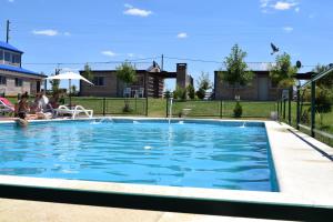 a swimming pool with blue water in a yard at Complejo Ruca Anay (Casa de amigos) in San José