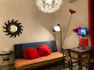ピアノ・ディ・ソレントにあるBelvedere Piano di Sorrentoの赤い枕とテーブル付きのソファが備わる客室です。