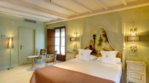 1 dormitorio con 1 cama grande y espejo grande en Sacristia de Santa Ana en Sevilla