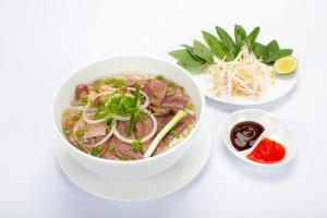 eine Schüssel Rindfleisch-Nudelsuppe auf einem weißen Tisch in der Unterkunft Catba Dream Hotel in Cát Bà