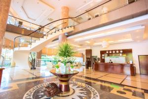 um lobby com uma escada e uma planta no meio em Dakruco Hotel em Buon Ma Thuot