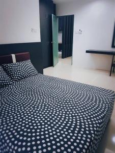 a bedroom with a bed with a black and white comforter at MyHome Ganggarak in Labuan