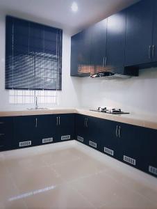 an empty kitchen with blue cabinets and a sink at MyHome Ganggarak in Labuan