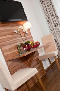 Zimmer mit einem Tisch, einem TV und einem Stuhl in der Unterkunft Landgasthof Am Sonnenhang in Vohenstrauß