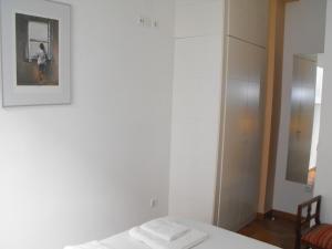Habitación blanca con cama y espejo en Karmapartment 2, en Sevilla
