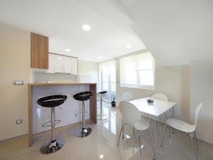 a kitchen with white chairs and a white table at Agent Lux Apartments in Jagodina