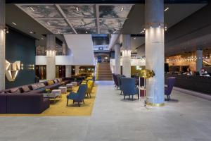 a lobby with couches and chairs and a bar at Original Sokos Hotel Presidentti Helsinki in Helsinki