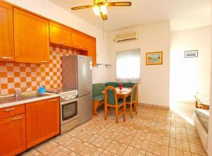 eine Küche mit einem Tisch und einem Kühlschrank aus Edelstahl in der Unterkunft Apartments Ivo 1328 in Fažana