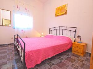 ein Schlafzimmer mit einem großen Bett mit einer rosa Tagesdecke in der Unterkunft Apartments Ivo 1328 in Fažana