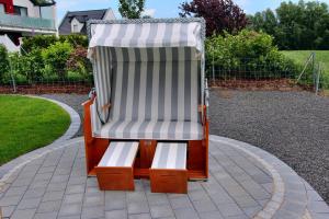 uma cadeira de baloiço sentada num pátio em Ferien_VILLA PACE em Göhren-Lebbin