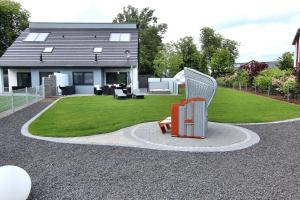 ein Haus mit einer Bank vor einem Hof in der Unterkunft Ferien-VILLA PACE in Göhren-Lebbin + 28 Fotos