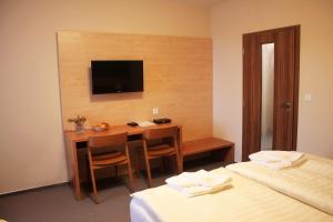 a hotel room with a desk and a television at Hotel Toč in Lipova Lazne