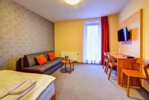a hotel room with a couch and a table at Hotel Toč in Lipova Lazne
