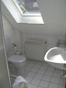 ヨルクにあるFerienwohnungen Lindemannのバスルーム(トイレ、シンク、天窓付)
