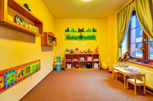 a childs room with yellow walls and a table and a window at Hotel Toč in Lipova Lazne
