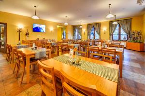 a restaurant with wooden tables and wooden chairs at Hotel Toč in Lipova Lazne