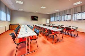 a large room with long tables and chairs at Hotel Toč in Lipova Lazne