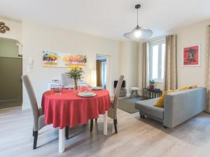 une salle à manger avec une table et des chaises rouges dans l'établissement Charme au cœur d'avignon, à Avignon
