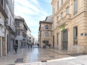 a city street with people walking down the street at Charme au cœur d'avignon in Avignon