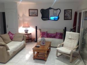 a living room with a couch and a table at La maison de Brijy in Pleslin-Trigavou +4 photos
