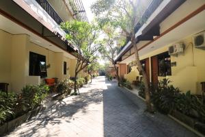 an empty courtyard of a building with trees and plants at Dee Mansion in Denpasar