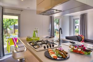 a kitchen with a stove and a plate of food on a counter at Camping Club l'Air Marin in Vias