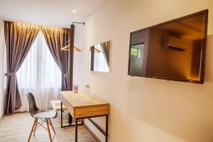 a room with a table and a television on a wall at The Marion Hotel Pelangi Branch in Johor Bahru